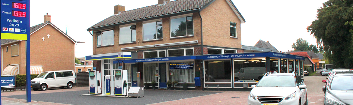Het pand van Autocentrum Wolvega aan de Beatrixstraat, met links de tankzuilen van het ARGOS-station, in het midden de showroom en rechts de werkplaats