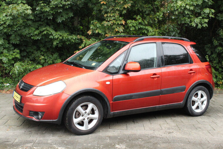 Oranjerode Suzuki SX4, zijaanzicht